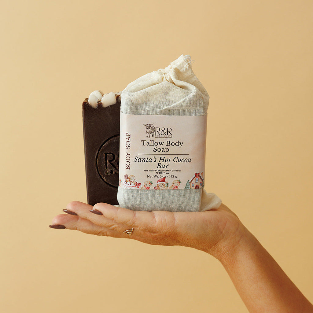 Hand holding two bars of soap against a beige background